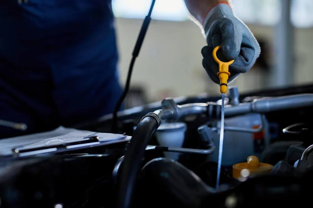 Technician performing engine oil change on a car in Dubai